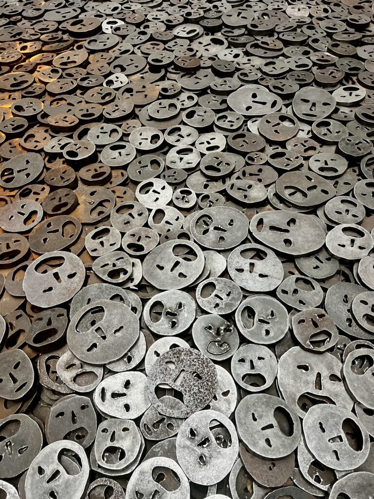 Installation “Shalekhet (Fallen Leaves)” by Israeli artist Menashe Kadishman at the Jewish Museum Berlin. The artwork consists of more than 10,000 iron faces spread across the floor, representing the pain, loss, and silenced voices of victims of war, violence, and the Holocaust.